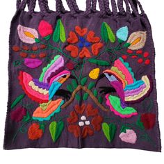 an embroidered bag with birds and flowers on purple fabric, hanging from a rope handle