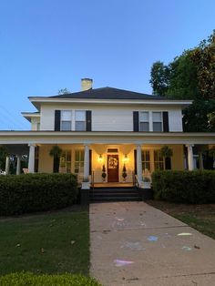 a white house with black shutters on the front door and steps leading up to it