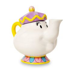 a white teapot with a purple and yellow hat on it's head, sitting in front of a white background