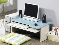 a computer desk with a monitor, keyboard and mouse on it in a living room