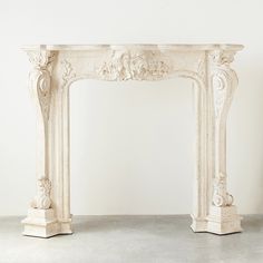 an ornate white fireplace surround in a room