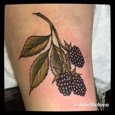 a tattoo with berries and leaves on it