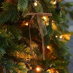 a close up of a christmas tree with lights on it and a ribbon hanging from the top