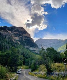 a car driving down a road in the mountains