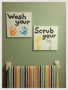 two hand prints are hanging on the wall next to a towel rack in a child's bathroom