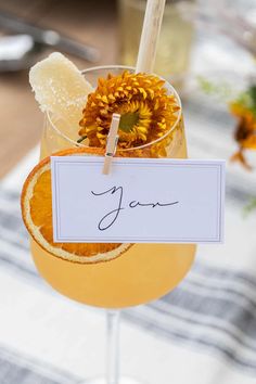 a glass filled with orange juice and garnished with an orange slice next to a note that says yes