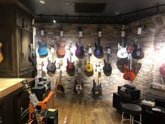 a room filled with lots of guitars hanging on the wall