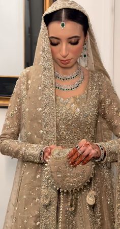 a woman wearing a bridal outfit and jewelry