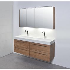 a bathroom vanity with two sinks and mirrors