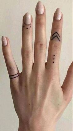 two fingers with small tattoos on them