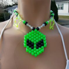 a green and black beaded necklace on a mannequin