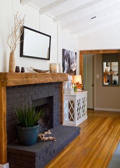 an image of a living room with fireplace and pictures on the wall in front of it