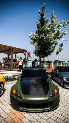 two cars parked next to each other on a brick road