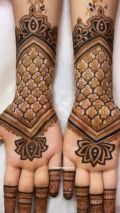 two hands with henna tattoos on them, one is showing the intricate pattern and the other has an ornate design