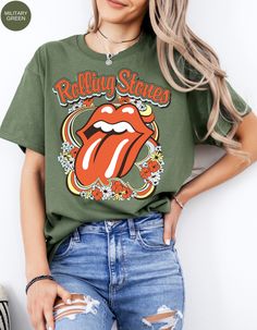 Step back in time and rock out in style with our Vintage Flower Rolling Stone Tee! 🌸🎸 This retro-inspired t-shirt features a classic Rolling Stone logo beautifully intertwined with vibrant flowers, capturing the free-spirited essence of rock 'n' roll and the timeless charm of the 70s. 🌼✨ Crafted from super-soft, high-quality fabric, this tee offers ultimate comfort and a perfect fit, making it an essential addition to your wardrobe. Whether you're heading to a concert, a festival, or just channeling your inner rock star, this tee will have you looking effortlessly cool and totally groovy. 🌟👕 Get ready to roll and bloom with style! 🌿🎶🛒 Retro Relaxed Fit T-shirt For Music Festival, Retro Green Printed T-shirt, Green Summer Concert Tops, Green Summer Concert Top, Green Summer Top For Concerts, Hippie Crew Neck T-shirt For Music Festival, Trendy Fall Music Festival T-shirt, Trendy Fall T-shirt For Music Festival, Trendy T-shirt For Music Festival In Fall