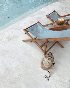 a hat is sitting on a chair next to a pool with a ball in it