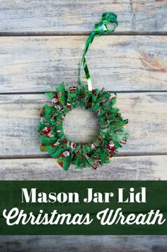 mason jar lid christmas wreath hanging on a wooden wall with text overlay that reads mason jar lid christmas wreath