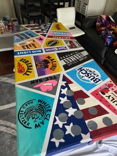 a long table covered with many different colored stickers on it's sides and two black chairs in the background