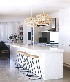 a kitchen with white counter tops and stools