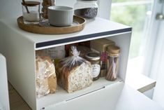 an open refrigerator with bread, jams and other food items on the door shelf