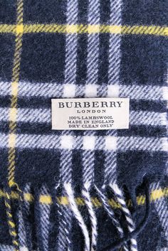 Stay stylish and cozy all winter long with this Burberry plaid lambswool scarf. In navy, white, and yellow, this scarf adds a pop of color to any outfit while the fringe trim adds a touch of fun. Perfect for layering over a timeless trench or adding a cute touch to your cold-weather look. Made in England 100% Lambswool Fringe hem Length 60" Width 12" Burberry Plaid, Burberry Scarf, Chunky Scarves, The Fringe, Yellow Plaid, Tartan Pattern, Fringe Trim, Scarfs, Navy White