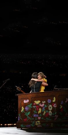 two people hugging each other on stage