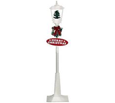 a white lamp post with a merry christmas sign on it's top and a red bow around the neck