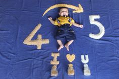 a baby laying on top of a blue blanket with numbers written in it and sand