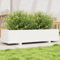 a large white planter sitting on top of a cement slab next to a wooden bench