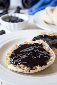 two pieces of bread with blueberry jam on them are sitting on a white plate