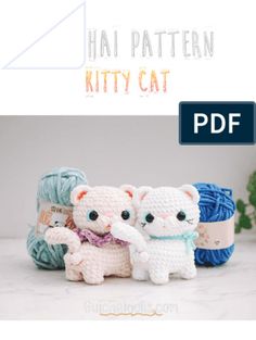 two crocheted cats sitting next to each other with yarn balls in the background