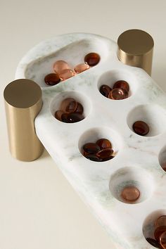 a marble tray with gold and brown buttons on it, next to a cup holder