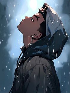 a man in the rain with his head covered by a hoodie looking up into the sky