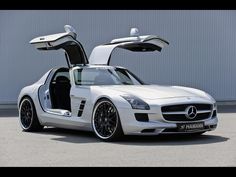 a white mercedes sls parked in front of a building