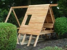 a wooden structure in the middle of some bushes