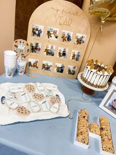 a table topped with cookies and desserts on top of a blue table cloth