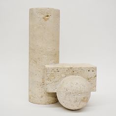 three cement objects sitting next to each other on a white surface with no one around them