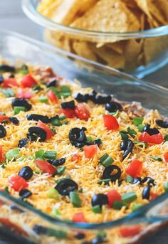 a casserole dish with black olives, peppers and cheese