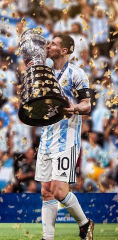 the soccer player is kissing the trophy while confetti falls in front of him