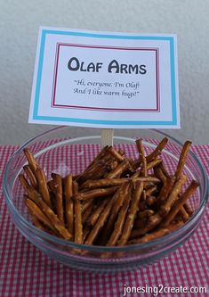 a bowl filled with pretzels sitting on top of a red and white checkered table cloth