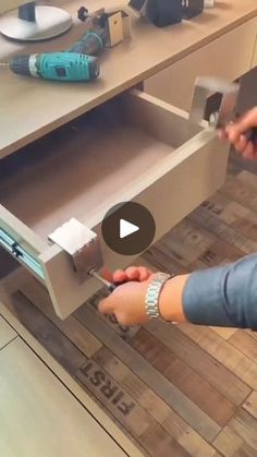 a woman is opening a drawer in the kitchen