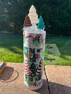 a cup that is sitting on the ground with some writing on it and trees inside