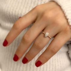 a woman's hand with red nails and a diamond ring on her left hand