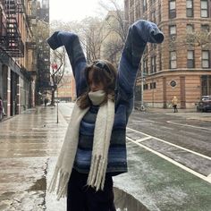 a woman standing in the rain with her arms up