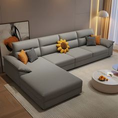 a living room with a large gray couch and sunflower pillow on the back of it