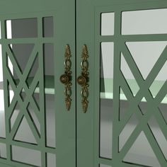 an ornate green cabinet with brass handles and knobs on the doors, in front of a white background