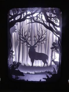 an image of a deer in the woods cut out of paper on a black background