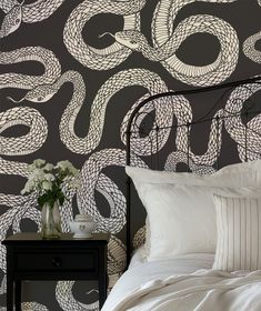 a black and white wallpaper with an intricate design on the headboard in a bedroom