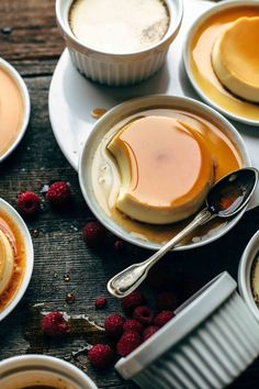 several desserts on plates with spoons and raspberries next to each other