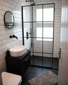 a bathroom with a sink, mirror and shower stall